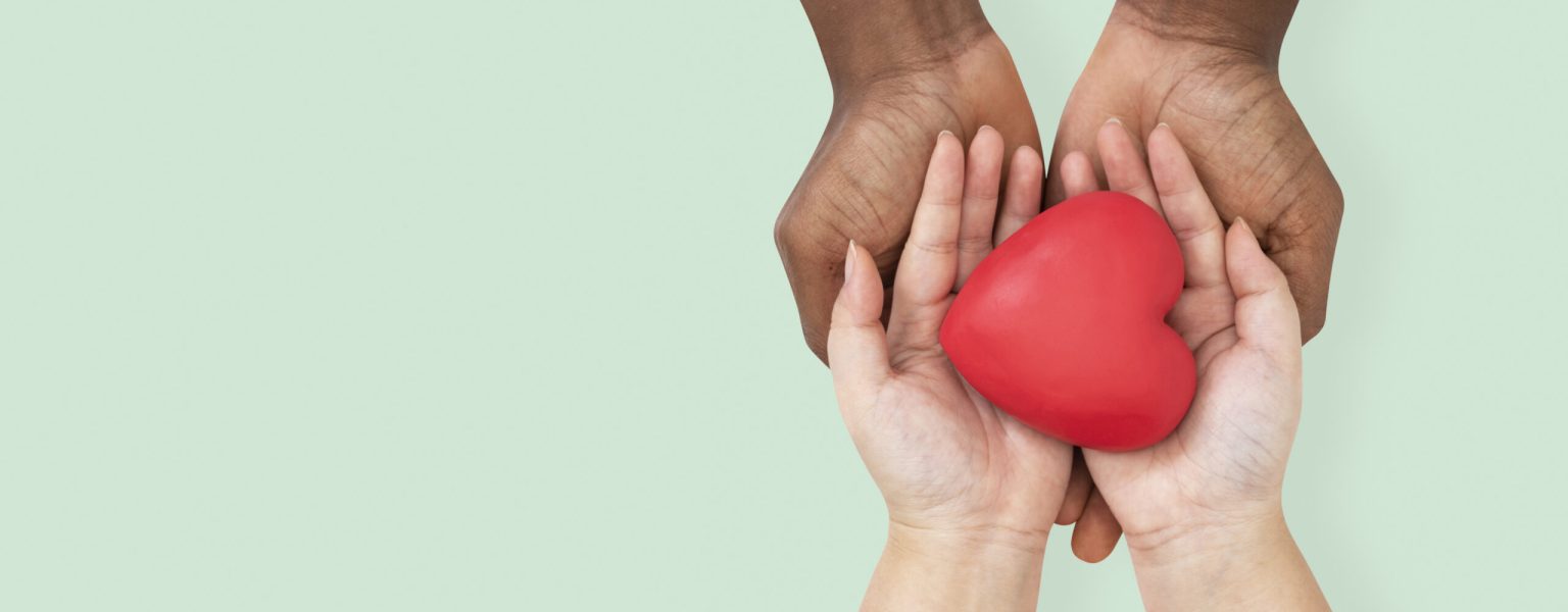 Hands cupping heart in love and relationship concept